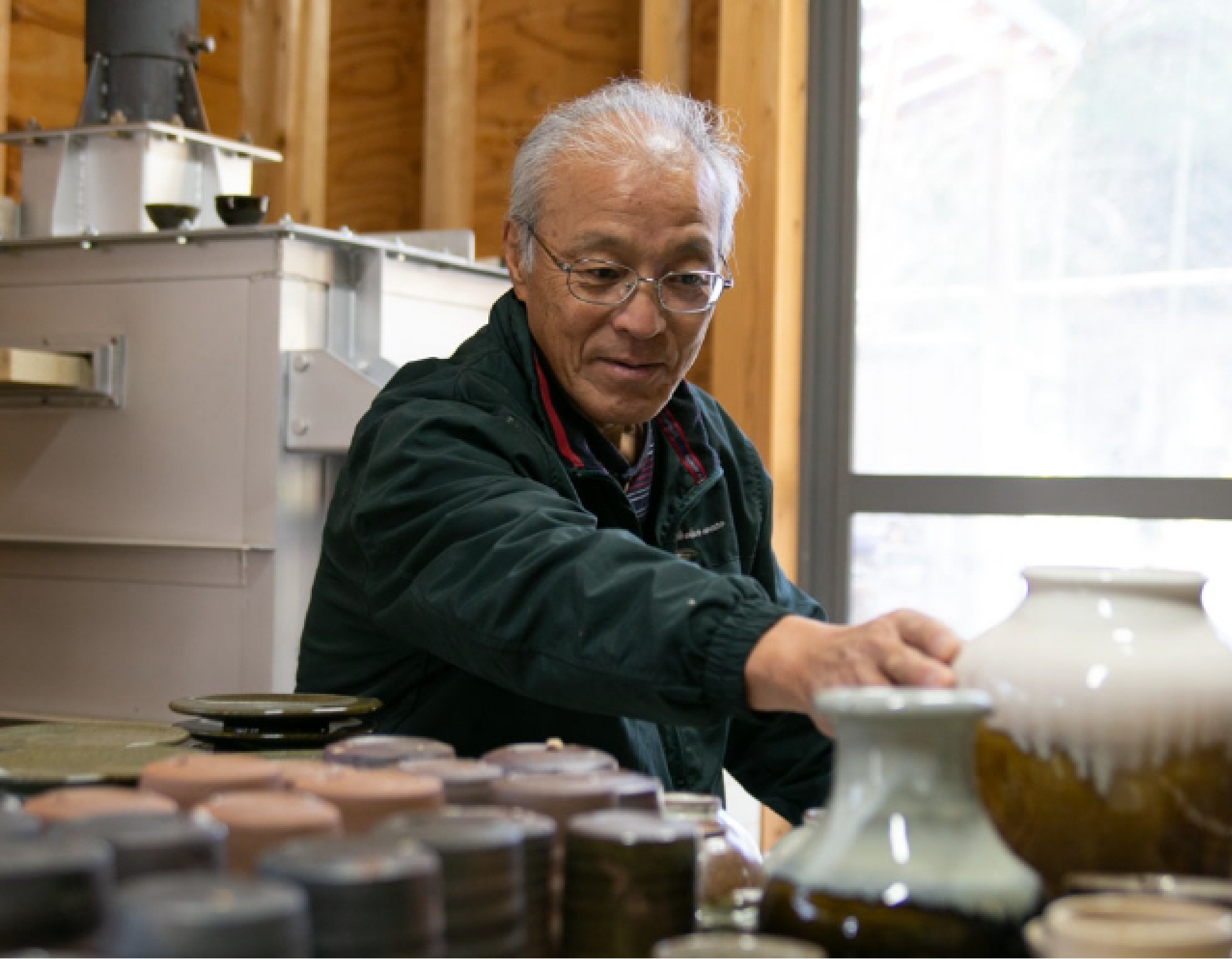 陶芸作品に手を伸ばす陶芸家